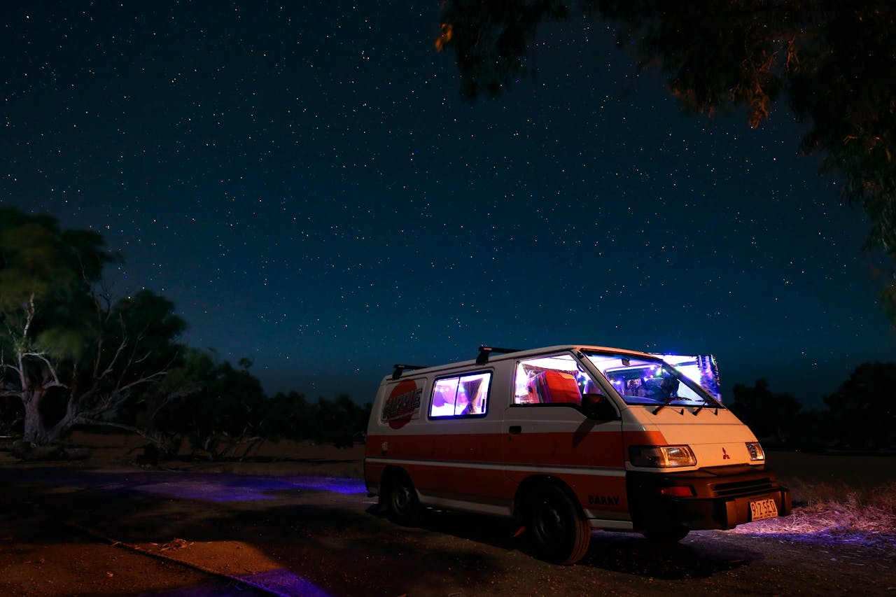services-03 A campervan parked under a starry night sky in the Australian outback, offering a tranquil nature adventure.