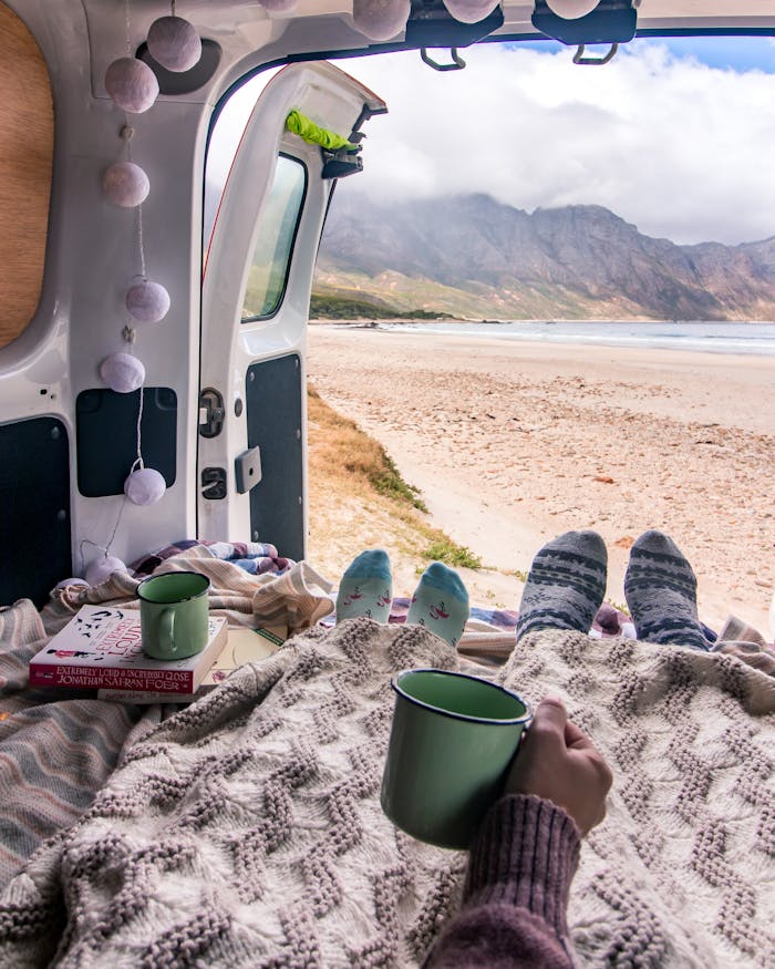 Relaxing in a camper van with a stunning view of a South African beach. Perfect for travel and van life enthusiasts.