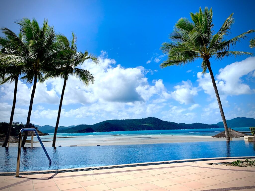 Stunning view of a tropical infinity pool overlooking the Whitsundays' pristine beaches.