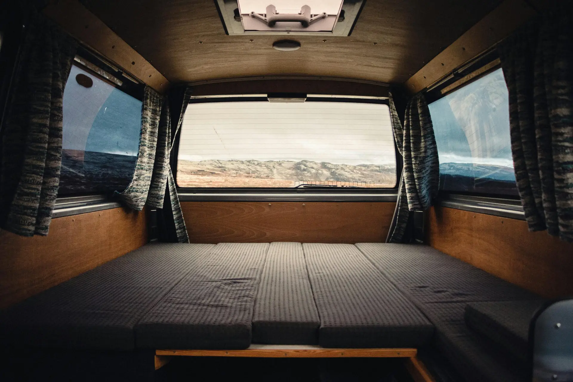 Comfortable and spacious camper van interior with scenic landscape view in Norway.